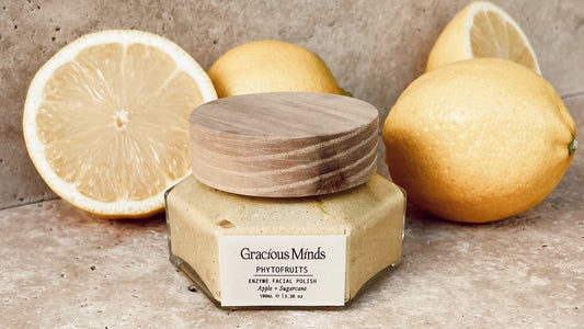 Gracious Minds Phytofruits Enzyme Facial Polish with lemons on a stone benchtop.