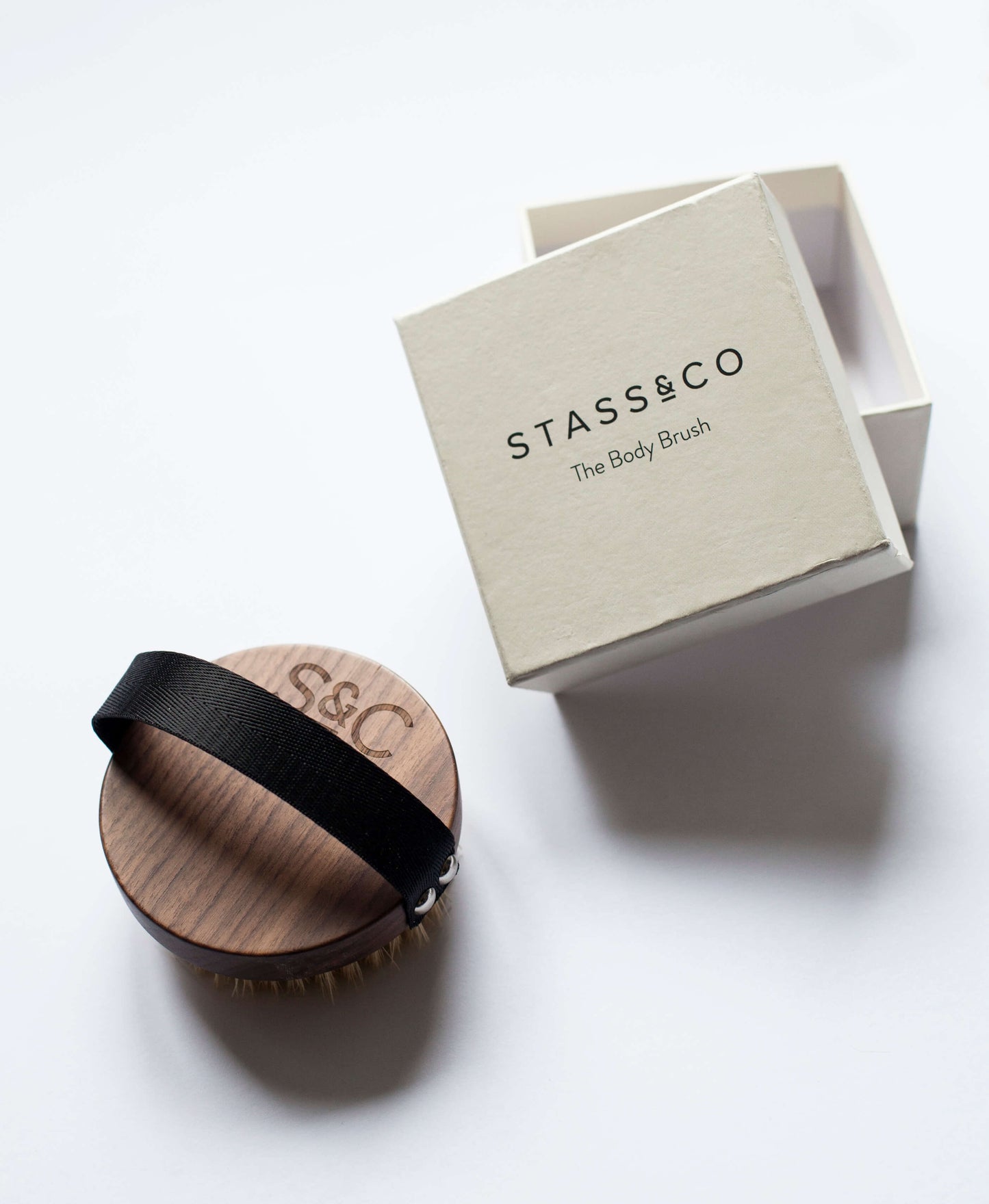 Stass & Co dry body brush with white product box.